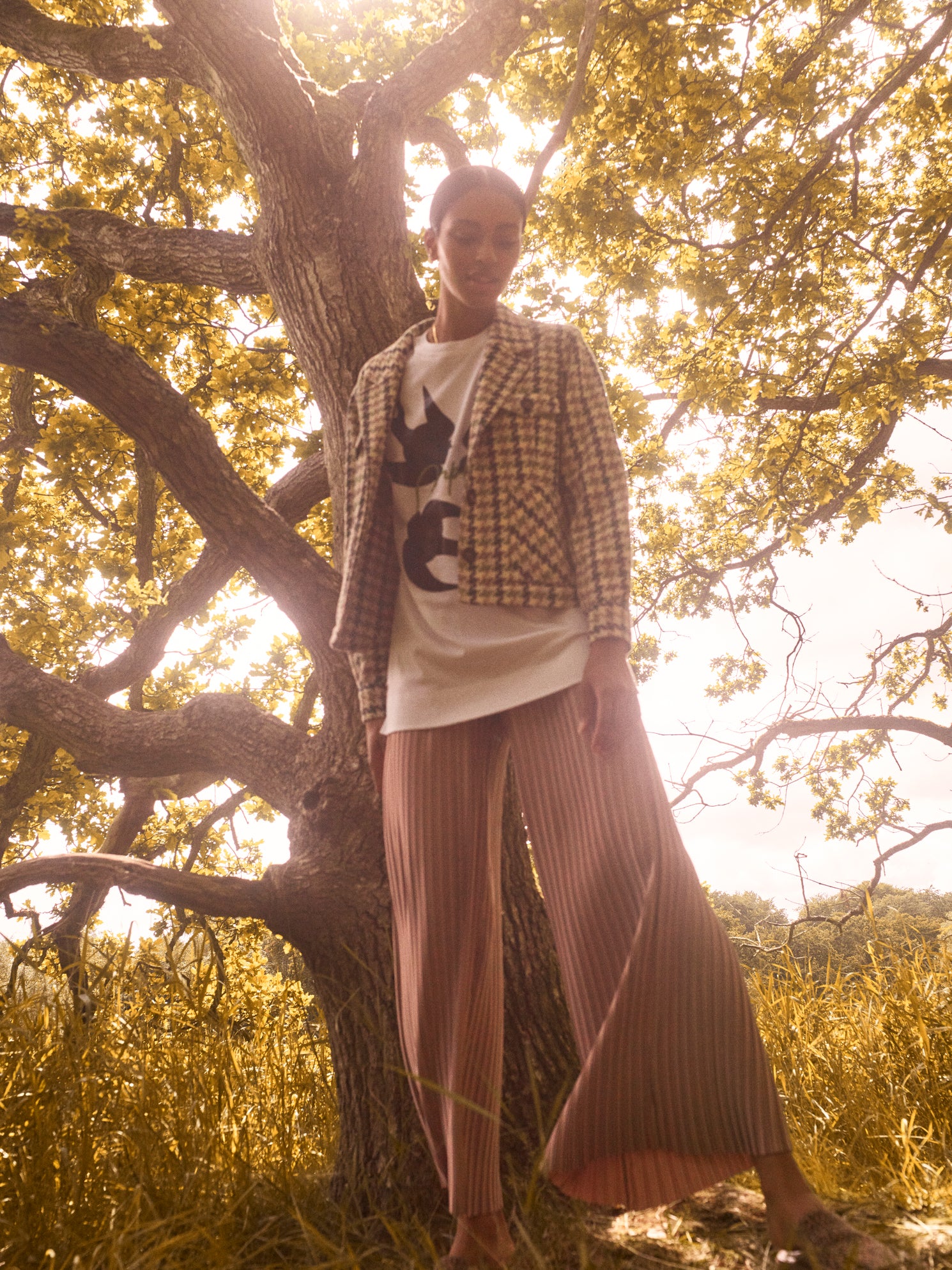 pleated pant in neutral based metallic beige gold. flare wide leg pant in flowing fabric, teamed with white tee and houndstooth jacket.