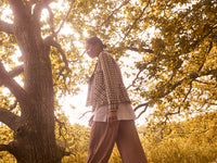 pleated pant in neutral based metallic beige gold. flare wide leg pant in flowing fabric, teamed with white tee and houndstooth jacket.