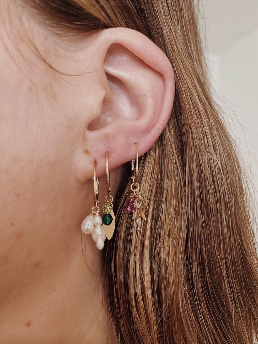 pearl cluster earrings on yellow gold hoops finerrings layered on ear
