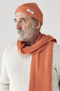 mcintyre merino unisex tabor beanie in bright orange wool modeled by man